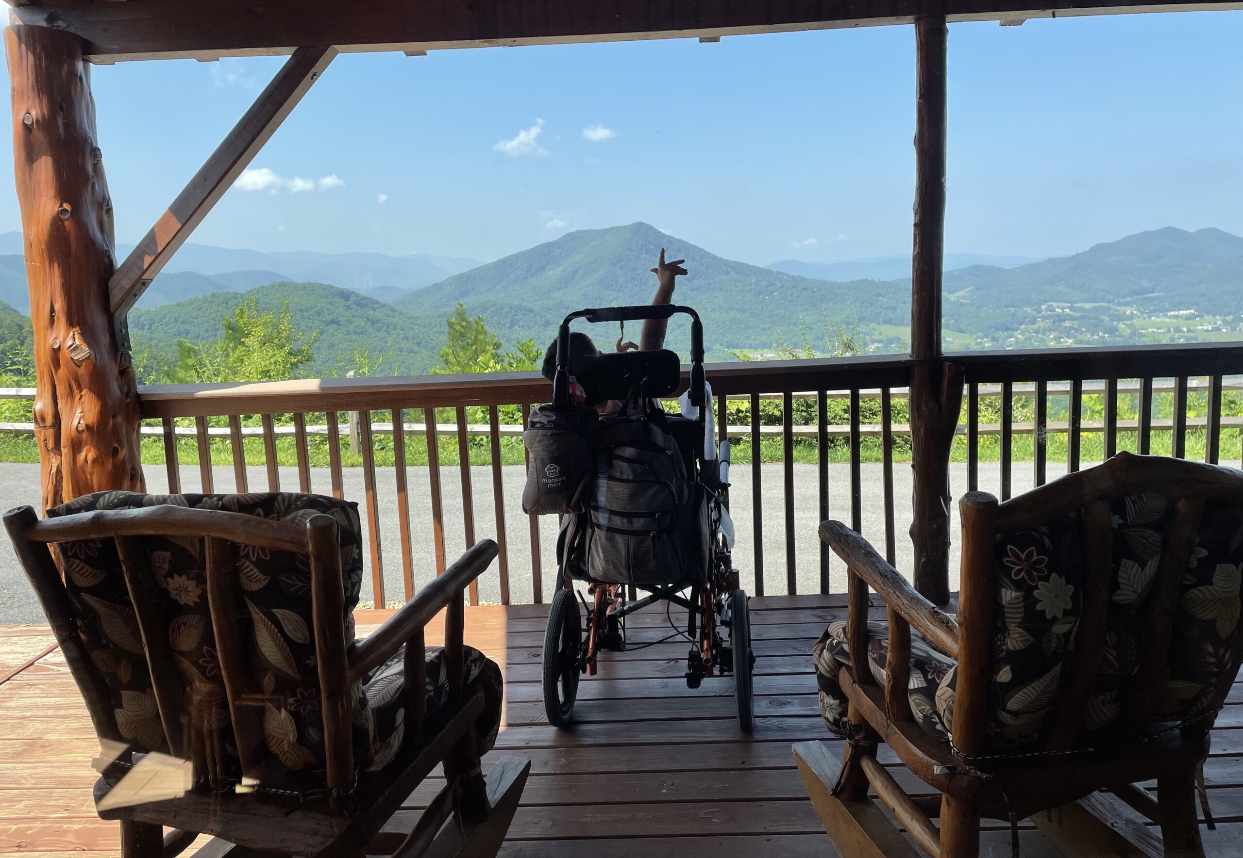 boy in wheelchair enjoying mountain views from our cabin deck